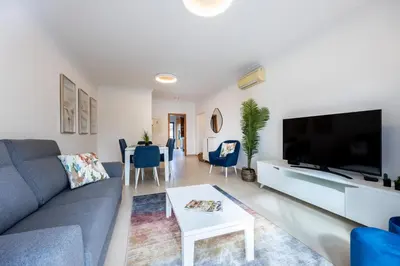 a living room with a couch and a tv and a table at Apartment República in Lagos