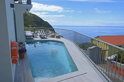 a swimming pool on the balcony of a building at Ocean escape with private pool in Arco da Calheta