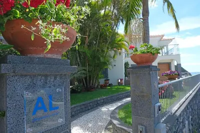 a villa with potted plants on a fence at Ocean escape with private pool in Arco da Calheta