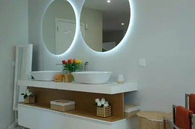a bathroom with two sinks and a mirror at Ocean escape with private pool in Arco da Calheta