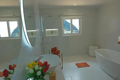 a white bathroom with two sinks and a shower at Ocean escape with private pool in Arco da Calheta