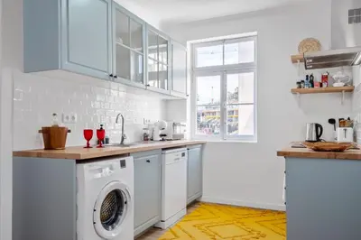 a white kitchen with a washer and dryer at Casa Bis Bis in Funchal