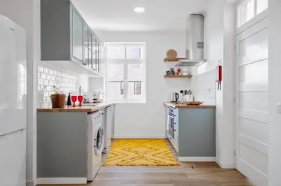 a kitchen with white cabinets and a yellow rug at Casa Bis Bis in Funchal