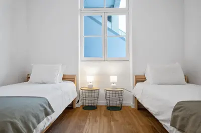 two beds in a room with a window at Casa Bis Bis in Funchal