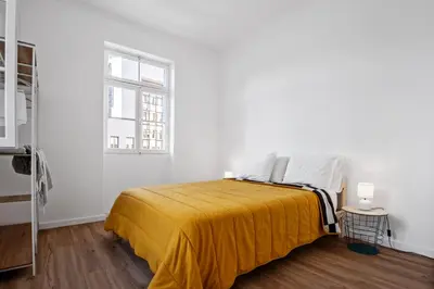 a white bedroom with a bed with a yellow blanket at Casa Bis Bis in Funchal