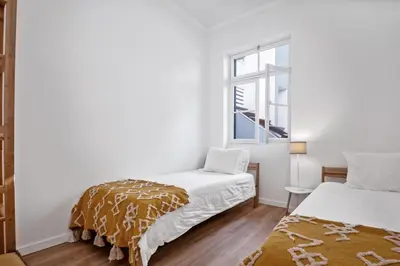 a white room with a bed and a window at Casa Bis Bis in Funchal