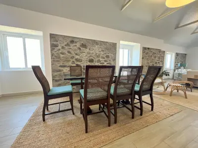 a dining room with a table and four chairs at Refúgio do Ilhéu in Porto Moniz