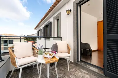 a balcony with two chairs and a table at Melblue in Estreito da Calheta
