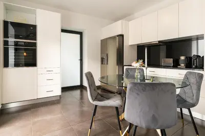 a kitchen with a glass table and chairs at Melblue in Estreito da Calheta