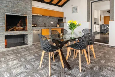 a dining room with a glass table and chairs at Melblue in Estreito da Calheta