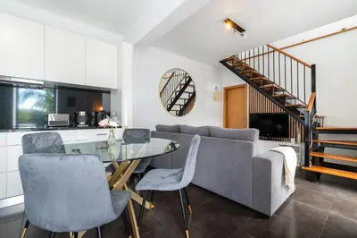 a living room with a table and a couch at Melblue in Estreito da Calheta