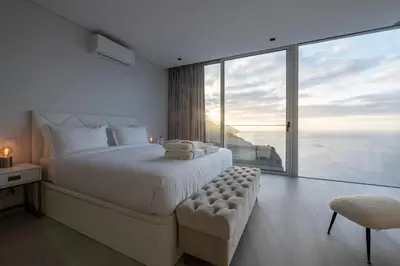 a bedroom with a large bed and a large window at Villa Pérola in Calheta