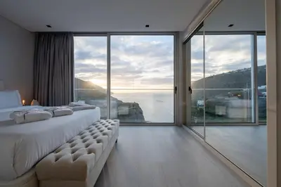 a bedroom with a large window with a view of the ocean at Villa Pérola in Calheta
