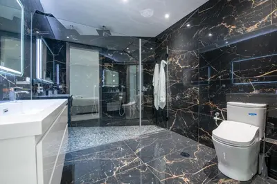 a black bathroom with a toilet and a sink at Villa Pérola in Calheta