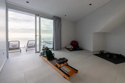 a living room with a treadmill and a large window at Villa Pérola in Calheta