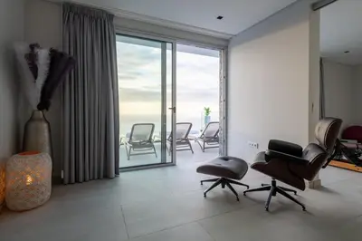 a living room with chairs and a large window at Villa Pérola in Calheta