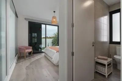 a dining room and living room with a glass table and chairs at OurMadeira - Vila Diana in Porto Santo