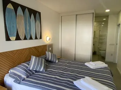 a bedroom with a bed with blue and white pillows at Concha is a NEW apartment * 5min walk to the beach in Luz