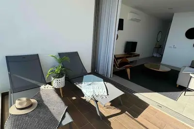a living room with a glass table and a hat at Concha is a NEW apartment * 5min walk to the beach in Luz