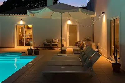 a patio with an umbrella and a swimming pool at Casa de Pinheiro in Aljezur