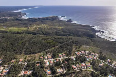 an aerial view of a house on a hill next to the ocean at Casa de Pinheiro in Aljezur