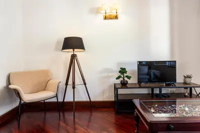 a living room with a lamp a chair and a table at Visconde Apartment in Ribeira Brava