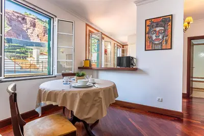 a dining room with a table and a large window at Visconde Apartment in Ribeira Brava