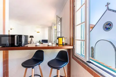 a kitchen with two black chairs at a counter at Visconde Apartment in Ribeira Brava