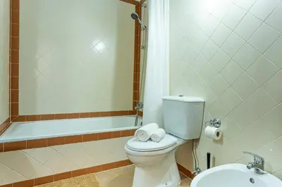 a bathroom with a toilet and a tub and a sink at Visconde Apartment in Ribeira Brava