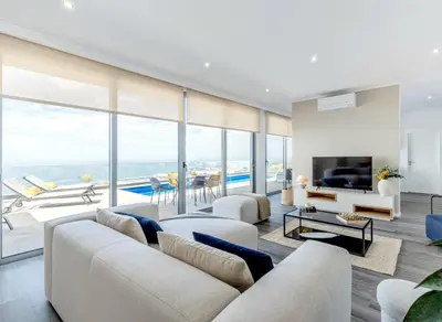 a living room with white furniture and large windows at Villa Serenity in Prazeres