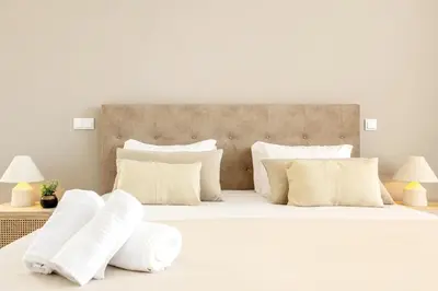 a white bedroom with a large bed with white pillows at Villa Serenity in Prazeres