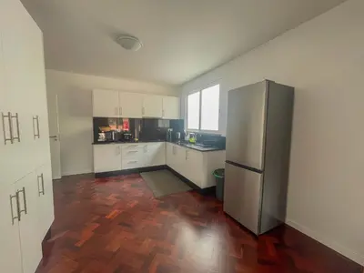 a kitchen with white cabinets and a stainless steel refrigerator at Villa Supranee Relaxation in Câmara de Lobos