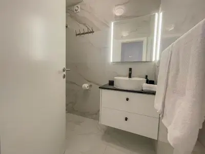 a white bathroom with a sink and a mirror at Villa Supranee Relaxation in Câmara de Lobos