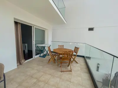 a dining room with a table and chairs on a balcony at Villa Supranee Relaxation in Câmara de Lobos