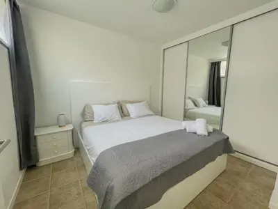 a bedroom with a large bed and a mirror at Villa Supranee Relaxation in Câmara de Lobos