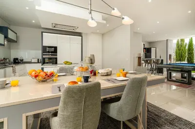 a dining table and chairs on the balcony of a building at Vincents Place I Ocean View I Swimming pool in Estreito da Calheta