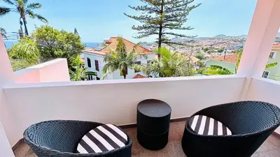 a balcony with two chairs and a view of the city at Villa Vera Downtown in Funchal