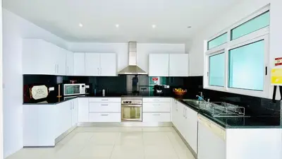 a kitchen with white cabinets and a stove top oven at Villa Vera Downtown in Funchal