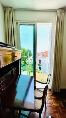 a living room with a table and a large window at Villa Vera Downtown in Funchal
