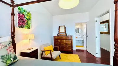 a bedroom with a bed and a chair and a dresser at Villa Vera Downtown in Funchal