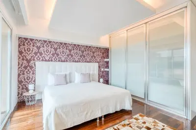a bedroom with a white bed and a red wall at PAKISA - Three bedroom apartment in Funchal