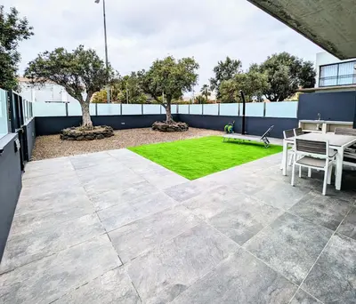 a patio with a table and green grass at Apartamentos Aurea - Porto Santo in Porto Santo