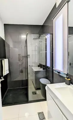 a bathroom with a glass shower and a toilet at Apartamentos Aurea - Porto Santo in Porto Santo