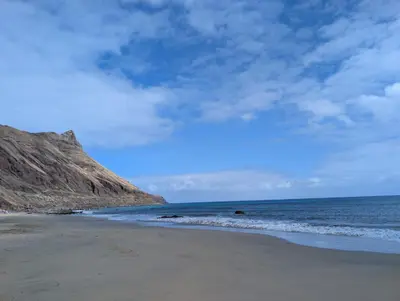 a beach with the ocean and a mountain at Apartamentos Aurea - Porto Santo in Porto Santo