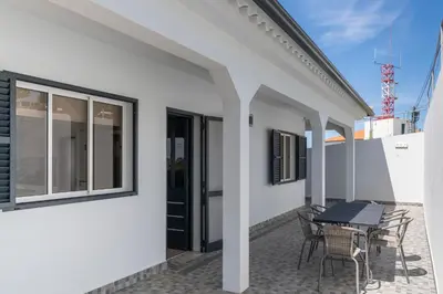 a patio with a table and chairs on a balcony at Paul's Holiday House in Ponta do Pargo
