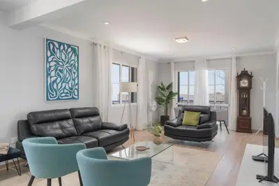 a living room with a couch and chairs and a clock at Paul's Holiday House in Ponta do Pargo