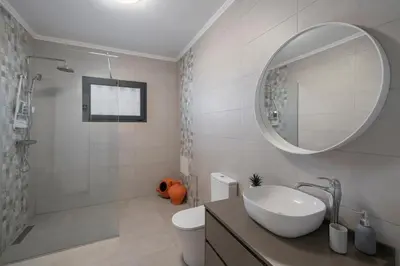 a white bathroom with a sink and a mirror at Paul's Holiday House in Ponta do Pargo