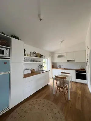 a kitchen with white cabinets and a table in it at Casa de Maio - New T2 - ARRIFANA BEACH 650 mts in Aljezur