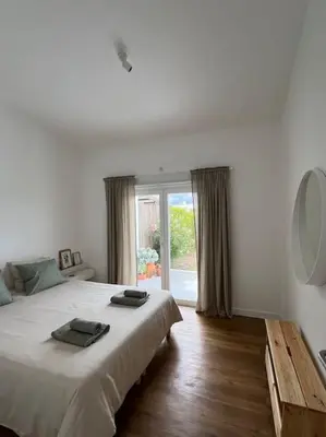 a white bedroom with a large bed and a window at Casa de Maio - New T2 - ARRIFANA BEACH 650 mts in Aljezur