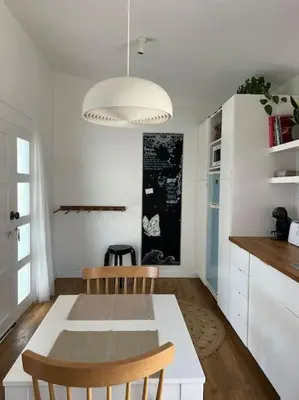 a kitchen with a white table and a table and chairs at Casa de Maio - New T2 - ARRIFANA BEACH 650 mts in Aljezur